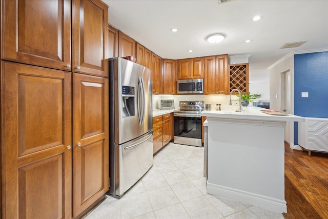 2513 Bering Dr Unit 13, Houston, TX 77057 - kitchen with appliances with stainless steel finishes, light countertops, tasteful backsplash, brown cabinetry, and a peninsula