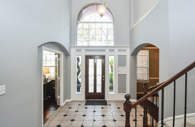 31 Hope Farm Rd, Missouri City, TX 77459 - tiled foyer entrance with a towering ceiling, healthy amount of natural light, arched walkways, and stairs