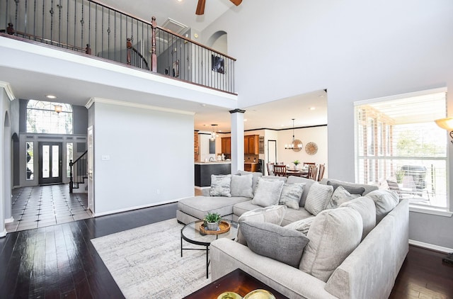 31 Hope Farm Rd, Missouri City, TX 77459 - living room with a high ceiling, decorative columns, ceiling fan, dark wood-style floors, and baseboards