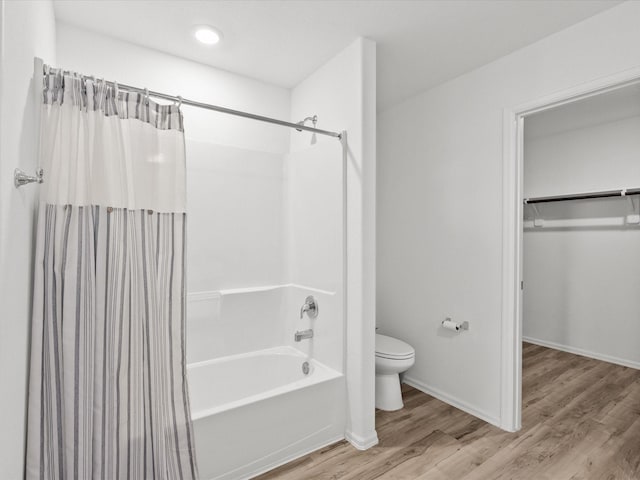 512 Maple Bnd, La Marque, TX 77568 - bathroom with toilet, shower / bath combination with curtain, wood finished floors, a spacious closet, and baseboards