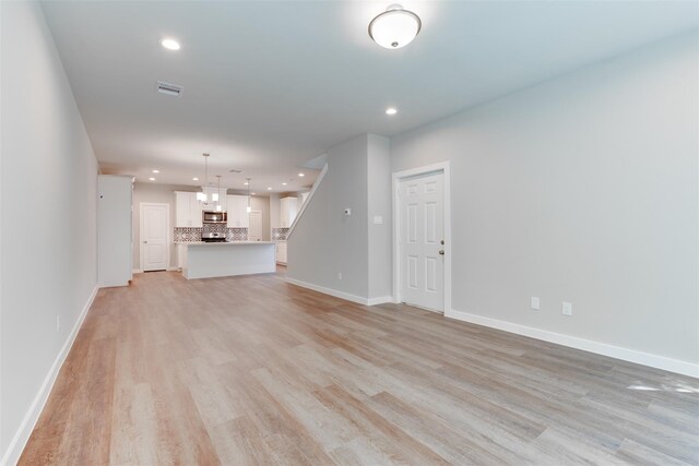 6615 Ezzard Charles Ln, Houston, TX 77091 - unfurnished living room with recessed lighting, light wood-style floors, and baseboards