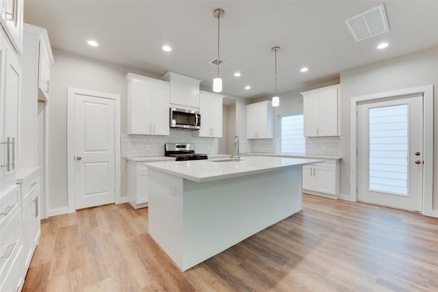 6615 Ezzard Charles Ln, Houston, TX 77091 - kitchen with stainless steel appliances, decorative backsplash, a sink, light wood-type flooring, and recessed lighting