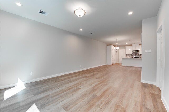 6615 Ezzard Charles Ln, Houston, TX 77091 - unfurnished living room with light wood-type flooring, recessed lighting, and baseboards