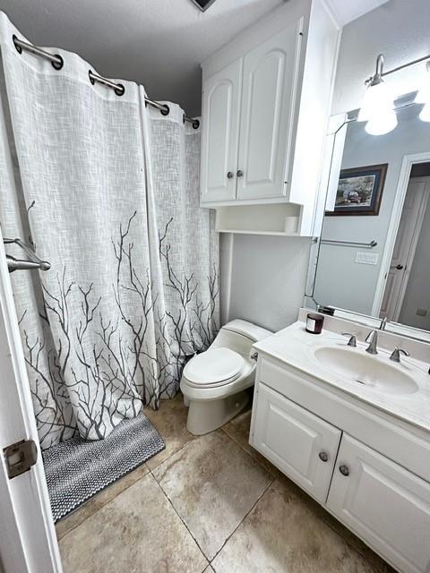 807 Trochta St, El Campo, TX 77437 - bathroom with vanity, toilet, tile patterned floors, and a shower with curtain