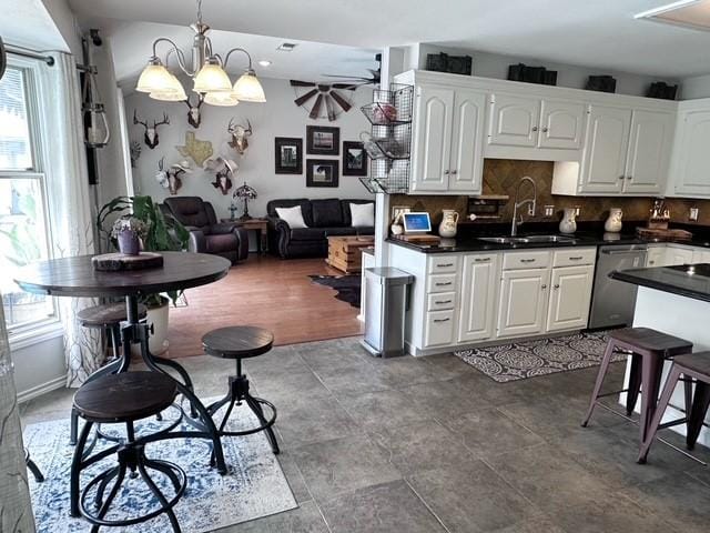 807 Trochta St, El Campo, TX 77437 - kitchen with dishwasher, a sink, dark countertops, white cabinetry, and recessed lighting