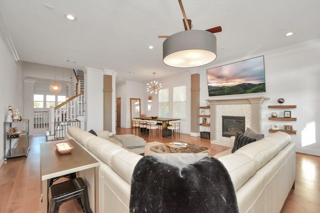 928 Dunbar St, Houston, TX 77009 - living area featuring crown molding, stairway, decorative columns, wood finished floors, and a chandelier