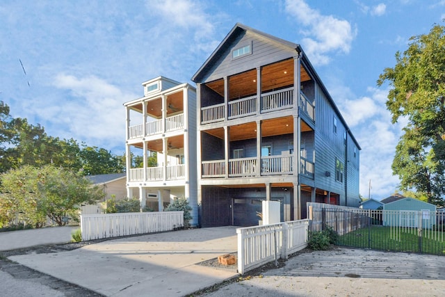 928 Dunbar St, Houston, TX 77009 - view of front facade featuring a balcony, concrete driveway, a fenced front yard, and ceiling fan