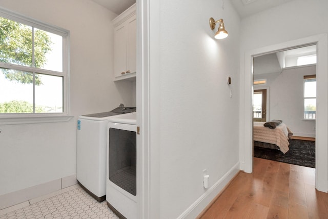 928 Dunbar St, Houston, TX 77009 - laundry room with cabinet space, separate washer and dryer, baseboards, and light wood-type flooring