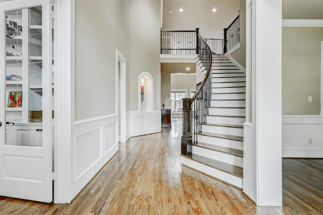 1418 Du Barry Ln, Houston, TX 77018 - foyer with a decorative wall, wood finished floors, stairs, a wainscoted wall, and arched walkways