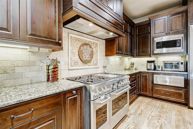 1418 Du Barry Ln, Houston, TX 77018 - kitchen with appliances with stainless steel finishes, a warming drawer, custom exhaust hood, decorative backsplash, and light stone counters