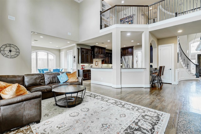 1418 Du Barry Ln, Houston, TX 77018 - living area featuring a towering ceiling, arched walkways, stairway, wood finished floors, and ornamental molding