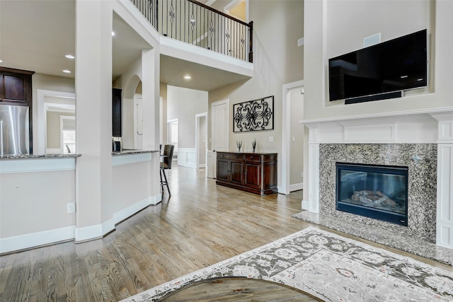 1418 Du Barry Ln, Houston, TX 77018 - living room with light wood-style flooring, a towering ceiling, recessed lighting, and a premium fireplace