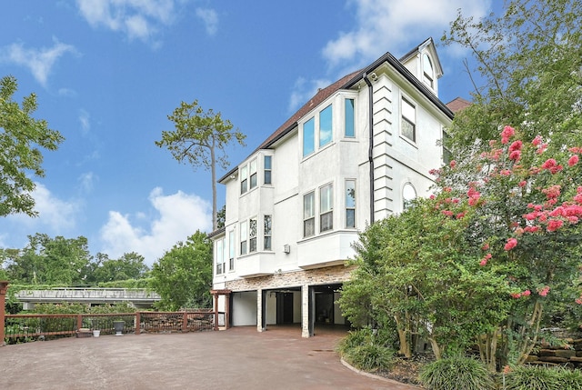 1 Magnolia Bend Dr, Hunters Creek Village, TX 77024 - view of building exterior with asphalt driveway and an attached garage