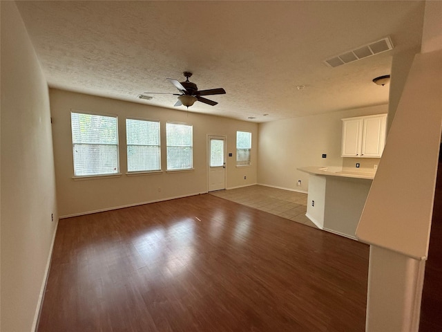 226 W Stedhill Loop, Conroe, TX 77384 - unfurnished living room with wood finished floors, ceiling fan, baseboards, and a textured ceiling