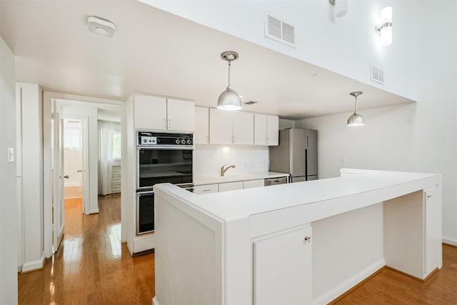 2322 Steel St Unit 19, Houston, TX 77098 - kitchen with freestanding refrigerator, light wood finished floors, light countertops, backsplash, and white cabinets