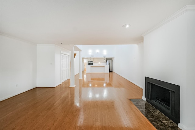 2322 Steel St Unit 19, Houston, TX 77098 - unfurnished living room featuring a fireplace with flush hearth, light wood finished floors, crown molding, and baseboards
