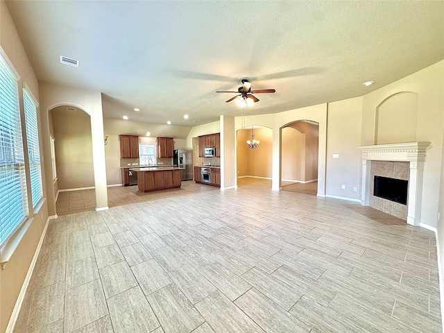 2115 Mooncrest Dr, Houston, TX 77089 - unfurnished living room with ceiling fan, a tiled fireplace, baseboards, recessed lighting, and a textured ceiling