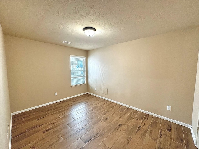2115 Mooncrest Dr, Houston, TX 77089 - empty room with wood finished floors, baseboards, and a textured ceiling