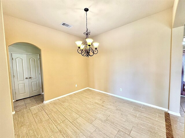 2115 Mooncrest Dr, Houston, TX 77089 - empty room with arched walkways, a chandelier, baseboards, and wood tiled floors