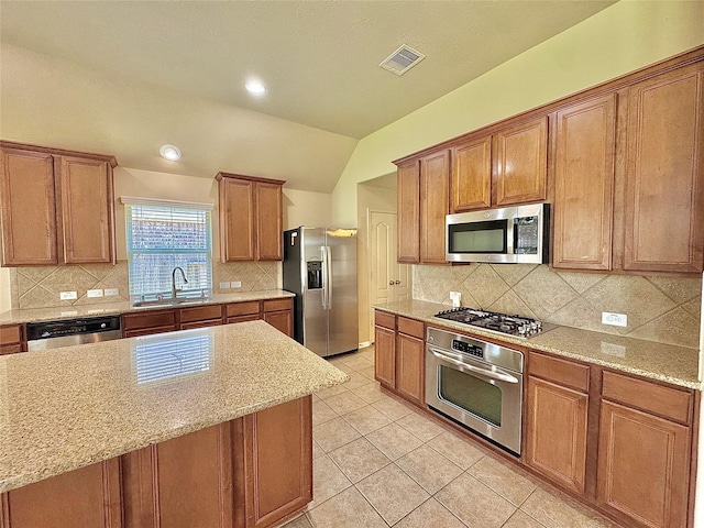 2115 Mooncrest Dr, Houston, TX 77089 - kitchen with appliances with stainless steel finishes, a sink, vaulted ceiling, light tile patterned floors, and decorative backsplash