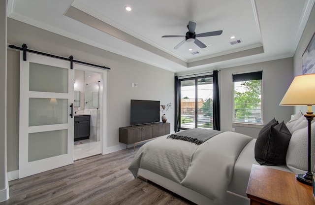 1708 Capron St Unit A, Houston, TX 77020 - bedroom featuring a raised ceiling, a barn door, ornamental molding, wood finished floors, and ensuite bath