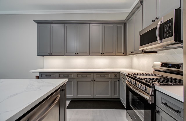 1708 Capron St Unit A, Houston, TX 77020 - kitchen featuring stainless steel appliances, gray cabinetry, decorative backsplash, and ornamental molding