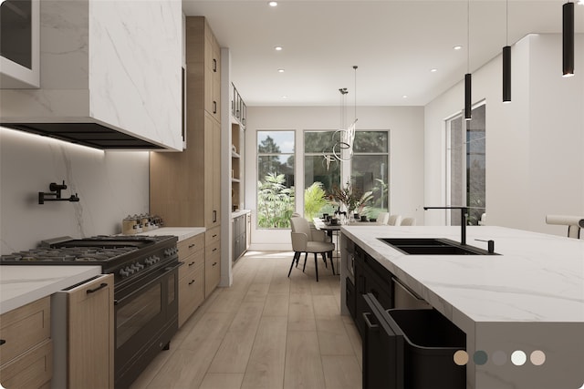 1407 Indiana St, Houston, TX 77006 - kitchen with black gas range oven, a sink, light wood finished floors, recessed lighting, and decorative light fixtures