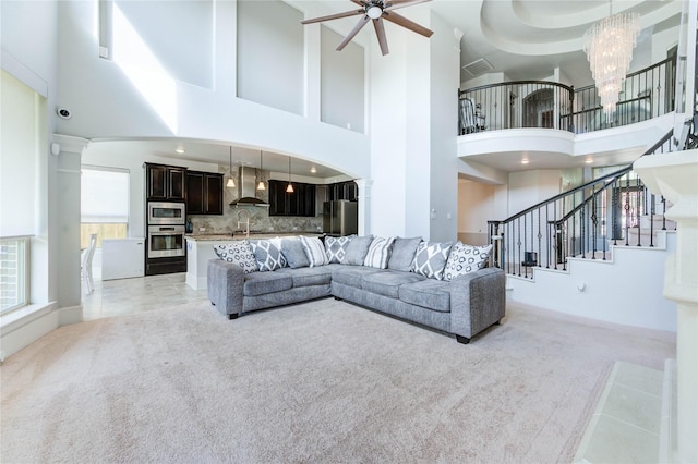 1103 River Delta Ln, Rosenberg, TX 77469 - living area featuring light carpet, a towering ceiling, ceiling fan, stairs, and a chandelier