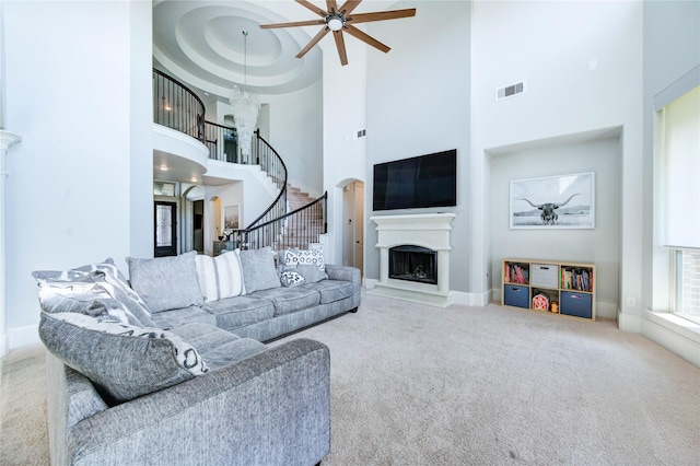 1103 River Delta Ln, Rosenberg, TX 77469 - living area with a high ceiling, ceiling fan, stairway, a fireplace with raised hearth, and carpet floors