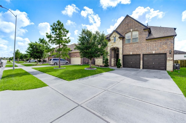 1103 River Delta Ln, Rosenberg, TX 77469 - french country home with brick siding, concrete driveway, a front lawn, a garage, and a shingled roof