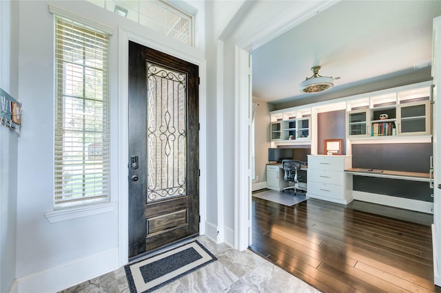 1103 River Delta Ln, Rosenberg, TX 77469 - entrance foyer with built in study area, baseboards, and wood finished floors