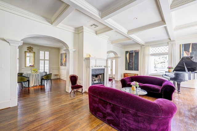 200 Westmoreland St, Houston, TX 77006 - living room featuring decorative columns, arched walkways, a fireplace, beam ceiling, and wood finished floors