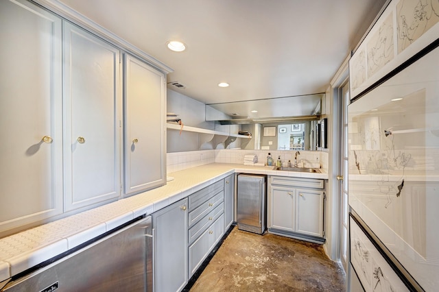 200 Westmoreland St, Houston, TX 77006 - kitchen featuring gray cabinetry, a sink, unfinished concrete flooring, decorative backsplash, and open shelves