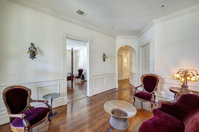 200 Westmoreland St, Houston, TX 77006 - living area featuring arched walkways, hardwood / wood-style floors, a decorative wall, crown molding, and a wainscoted wall