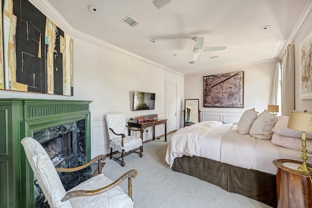 200 Westmoreland St, Houston, TX 77006 - carpeted bedroom with crown molding, a high end fireplace, a decorative wall, and ceiling fan