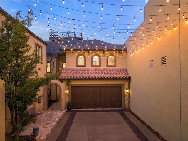 3224 Alabama Ct, Houston, TX 77027 - mediterranean / spanish house featuring stucco siding, a tile roof, an attached garage, and asphalt driveway
