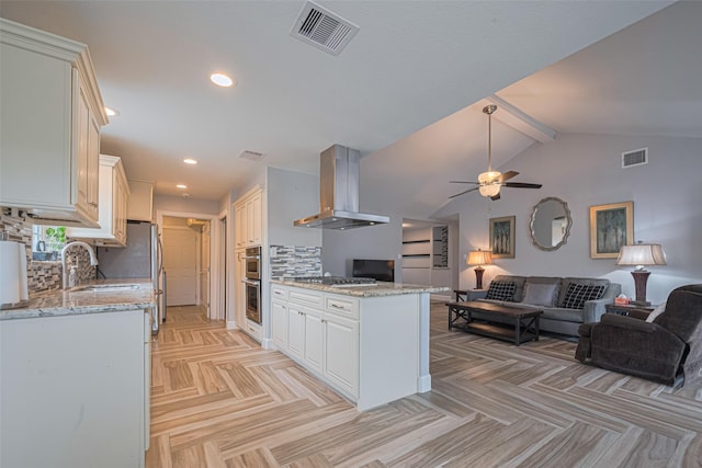 11211 Sageriver Dr, Houston, TX 77089 - kitchen featuring wall chimney range hood, open floor plan, a peninsula, ceiling fan, and a sink