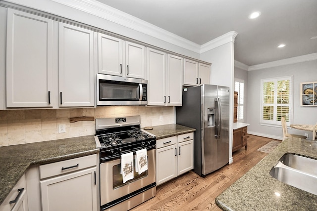 2223 Hilshire Trail Dr, Houston, TX 77080 - kitchen featuring appliances with stainless steel finishes, ornamental molding, a sink, light wood finished floors, and decorative backsplash