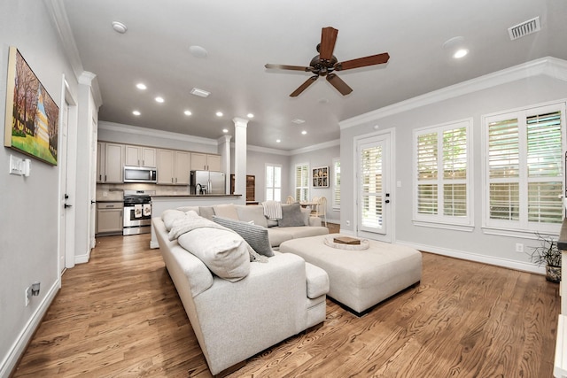 2223 Hilshire Trail Dr, Houston, TX 77080 - living area with decorative columns, light wood-style floors, baseboards, recessed lighting, and crown molding