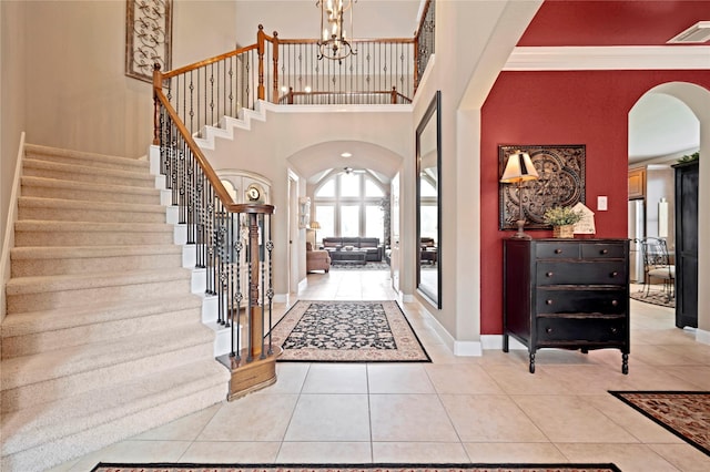 25606 Payton Chase Ct, Katy, TX 77494 - foyer with arched walkways, stairs, a chandelier, light tile patterned floors, and crown molding