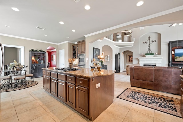 25606 Payton Chase Ct, Katy, TX 77494 - kitchen with arched walkways, light tile patterned floors, light stone countertops, a center island, and ornamental molding