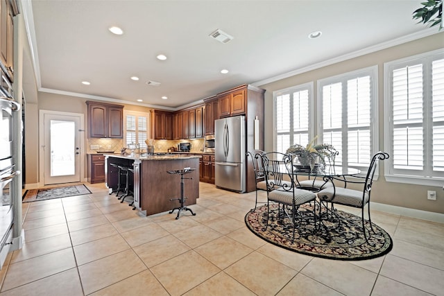 25606 Payton Chase Ct, Katy, TX 77494 - kitchen featuring appliances with stainless steel finishes, ornamental molding, recessed lighting, a kitchen island, and tasteful backsplash