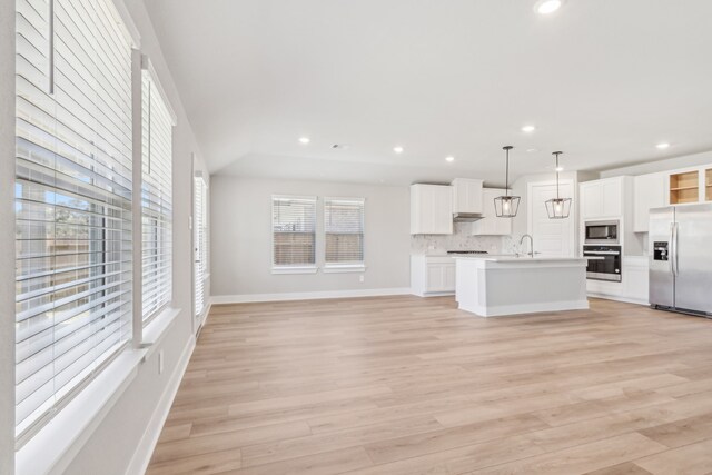 2010 Bluff Oak Ct, Conroe, TX 77304 - unfurnished living room with light wood-style floors, recessed lighting, baseboards, and a sink