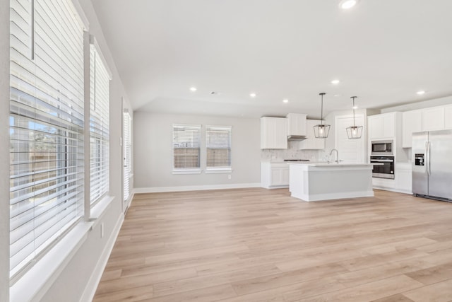 2010 Bluff Oak Ct, Conroe, TX 77304 - unfurnished living room with healthy amount of natural light, light wood-style flooring, recessed lighting, and baseboards