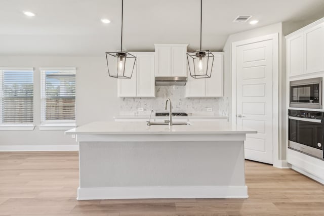 2010 Bluff Oak Ct, Conroe, TX 77304 - kitchen with stainless steel oven, built in microwave, light countertops, tasteful backsplash, and recessed lighting