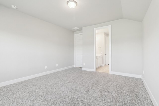 2010 Bluff Oak Ct, Conroe, TX 77304 - unfurnished bedroom featuring light colored carpet, baseboards, vaulted ceiling, and ensuite bathroom