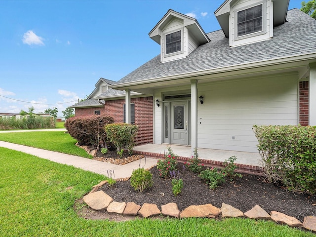 15615 Atwood Ln, Crosby, TX 77532 - view of front of property with brick siding, a front yard, a shingled roof, and a porch