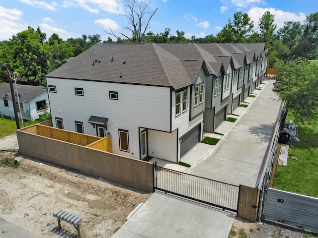 2410 Vaughn St Unit B, Houston, TX 77093 - rear view of property with a gate, a fenced front yard, a shingled roof, and a garage