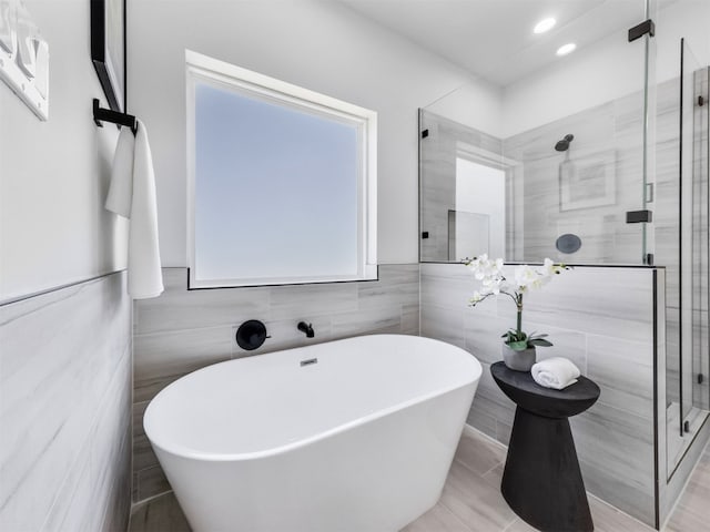 2410 Vaughn St Unit B, Houston, TX 77093 - bathroom with a freestanding bath, a stall shower, tile walls, recessed lighting, and wainscoting