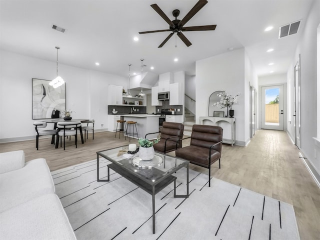 2410 Vaughn St Unit B, Houston, TX 77093 - living area featuring light wood-type flooring, ceiling fan, baseboards, stairs, and recessed lighting